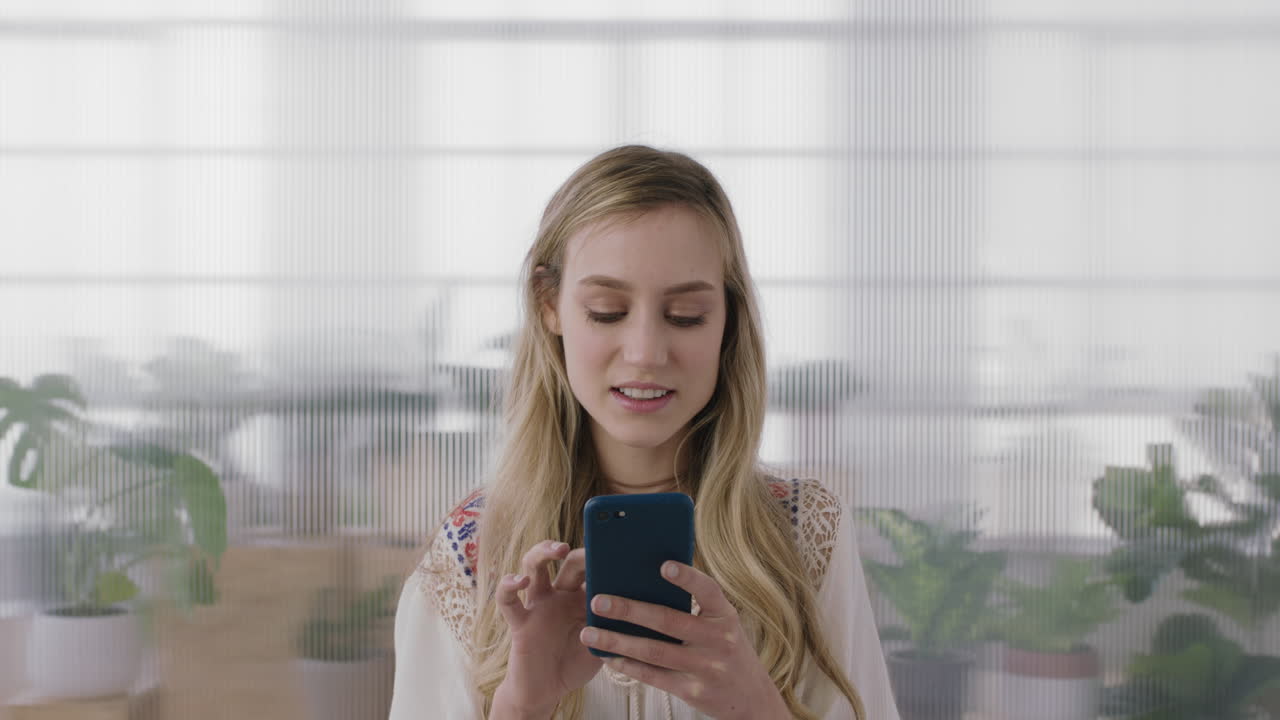ritratto di una bella donna d'affari bionda stagista che si diverte a mandare messaggi di testo navigando sui social media utilizzando la tecnologia mobile dello smartphone