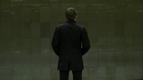 man standing in a dark subway station.