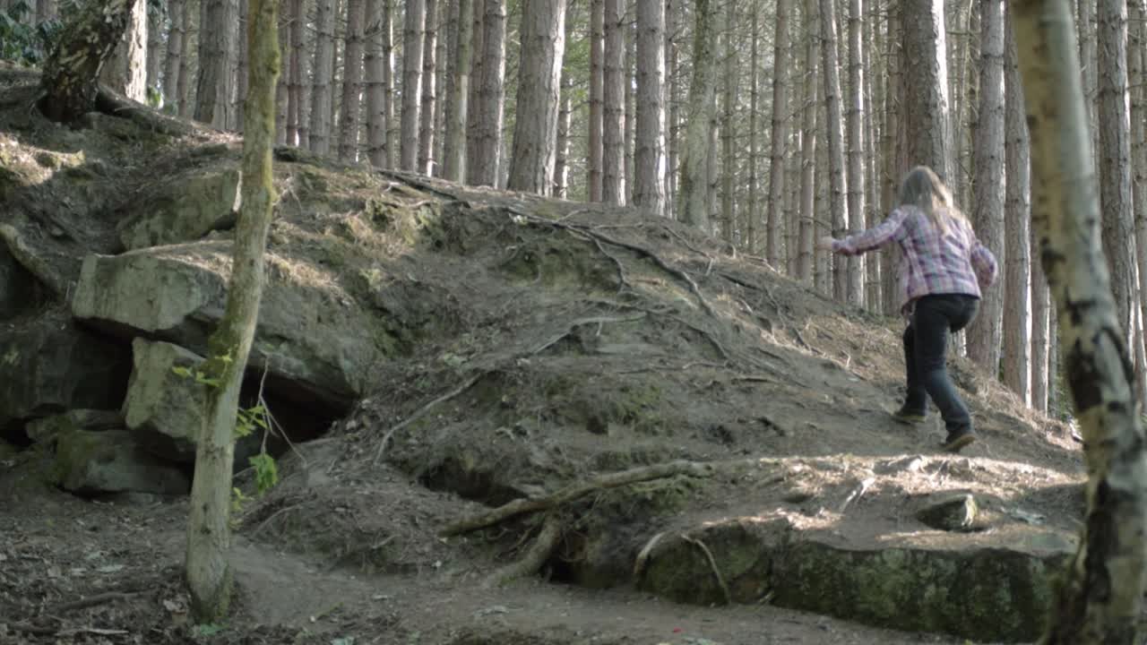 Woman exploring pine forest landscape wide shot