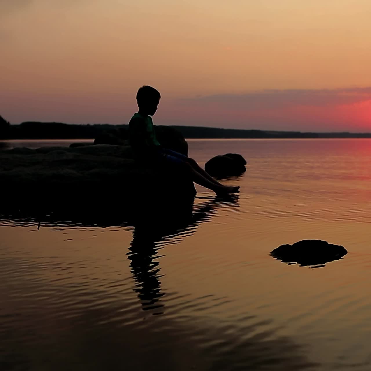 Boy Sitting by the Lake at Sunset