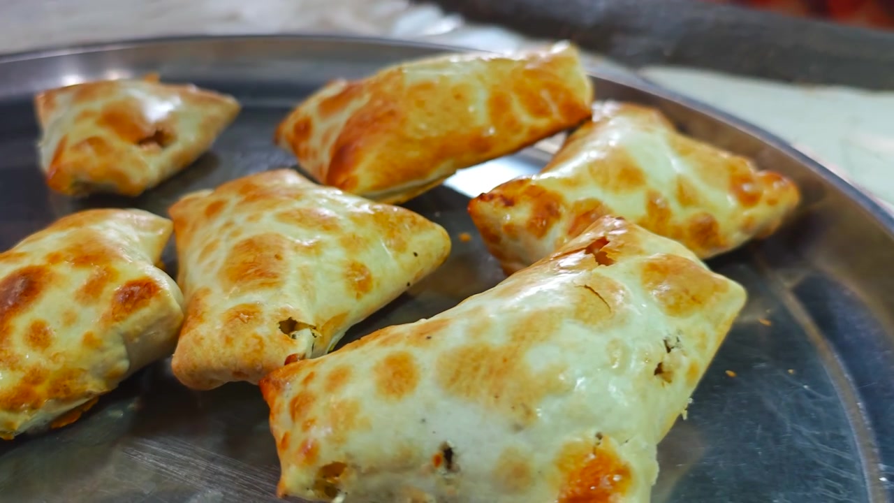 Chef sacando samosas recién horneadas de un horno tandoor tradicional