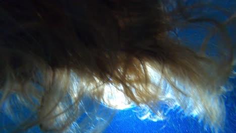 cabello de mujer bajo el agua en la piscina