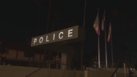 static shot of a led police sign with flags blowing behind