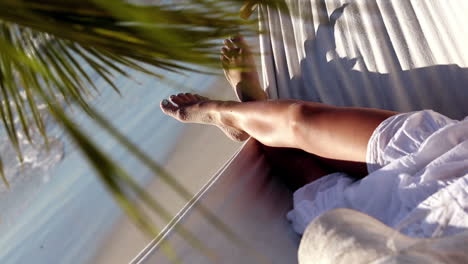 Woman-relaxing-in-a-hammock-under-a-palm-tree