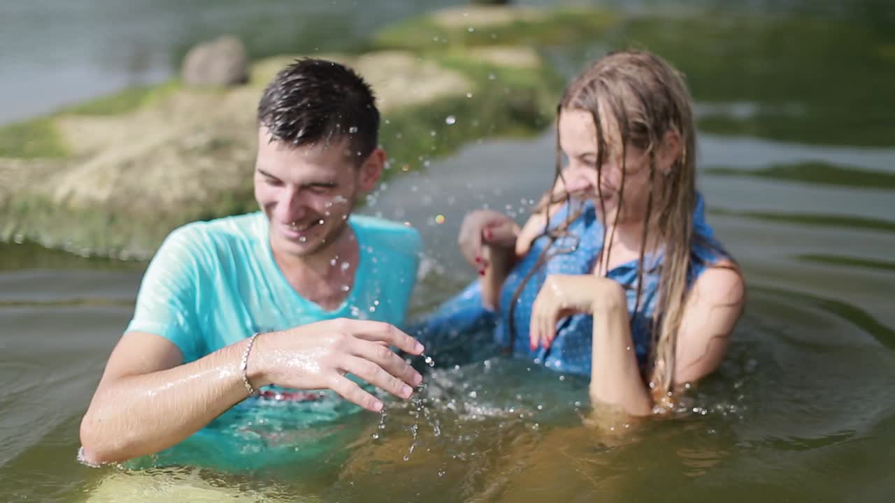 Couple Resting On River Bank. Smiling couple resting on river bank in nature