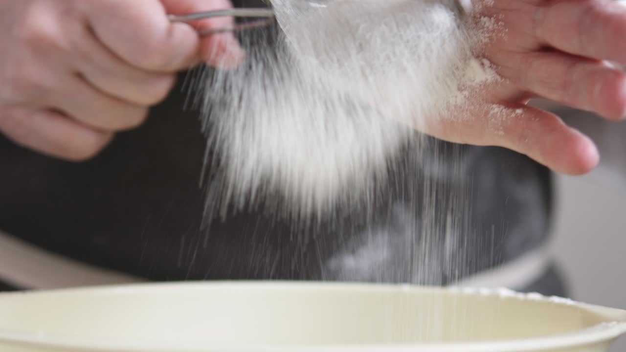 Female hands sifts the flour