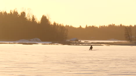 Silueta-De-Un-Solitario-Pescador-De-Hielo-En-Un-Lago-Congelado-En-Invierno