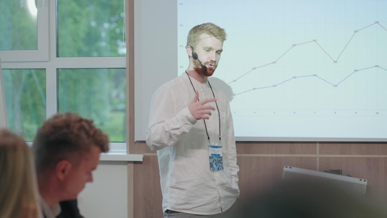 un joven especialista en tecnología de la información está presentando su informe en una reunión de negocios en una gran empresa