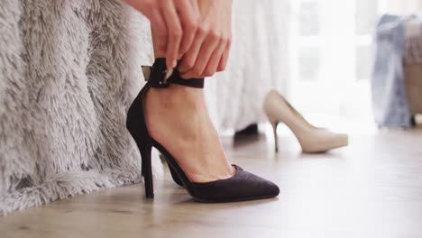 Video-of-biracial-woman-putting-black-high-heels-on