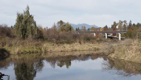 Timelapse-of-burnaby-lake-and-cars-and-trains-passing-by