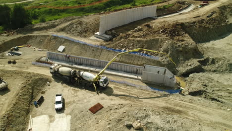 Aerial-drone-shot-of-heavy-machinery-working-on-a-dam-construction-site-in-the-mountains