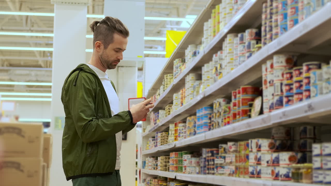 hombre comprando productos enlatados en una tienda de comestibles