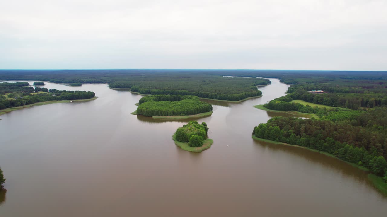 Scenic Masurian lake shore surrounded by greenery