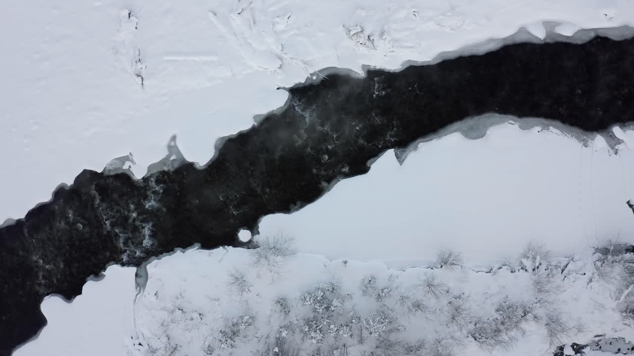 Bialka river flowing between snowy and frozen banks, Poland