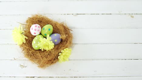 Painted-Easter-eggs-in-the-nest-on-wooden-surface