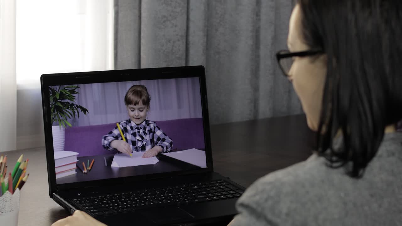 Woman teacher making video call on laptop with little pupil. Distance education