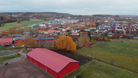 Roter-Pferdestall-Mit-Schwedischer-Stadt-Im-Hintergrund