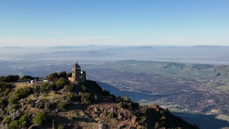 Aerial-view-of-Light-Beacon-on-summit-of-Mount-Diablo-State-Park-Green-hills-with-view-of-East-Bay-Area,-Concord,-Pittsburg,-Walnut-Creek,-California,-United-States-of-America