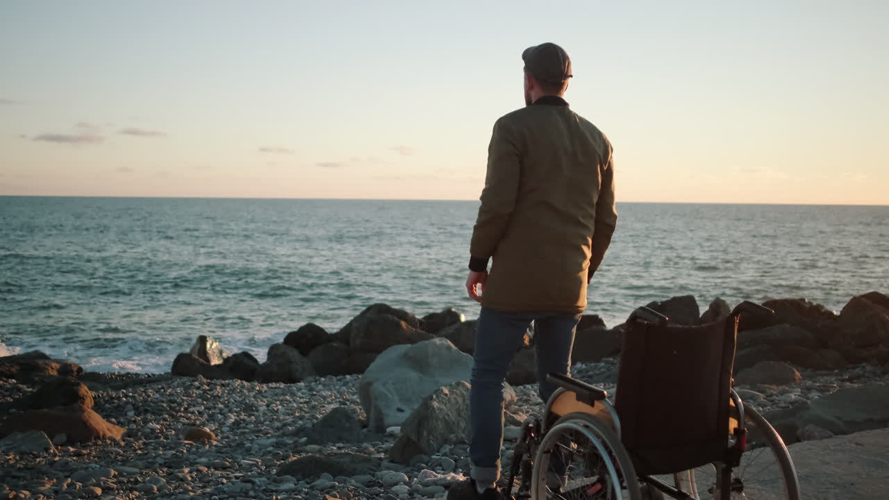 해변 에서 해 가 지는 것 을 즐기는 장애인 남자