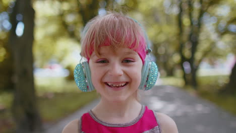 portrait of athletic sport runner child girl training, listening favorite music song in headphones