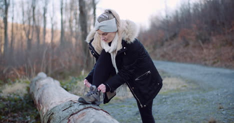 Beautiful-Female-Tourist-Tying-Shoe-On-Mountain-Trail-1