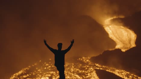 volcán pacaya, guatemala - una silueta de un hombre posando cerca de los brillantes ríos de lava derretida por la noche - foto de mano