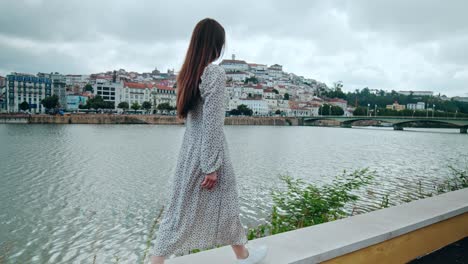 beautiful fashionable girl in a dress with long hair traveling in coimbra europe.