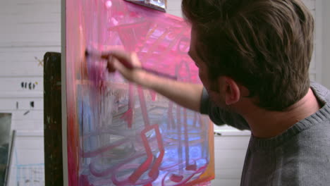 male artist working on painting in studio shot on r3d