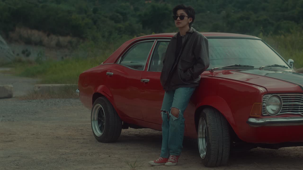 Woman by a vintage red car