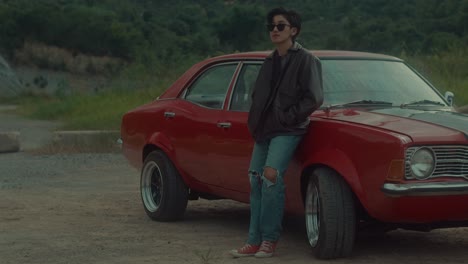 woman by a vintage red car