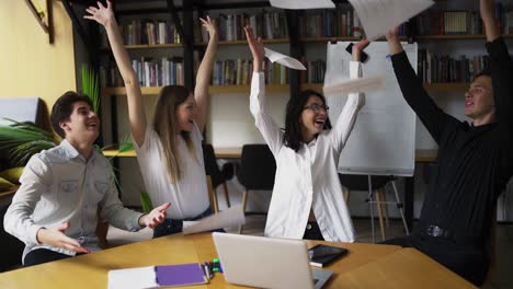 Grupo-Motivado-Disfruta-Del-éxito.-Tirar-El-Papel-Como-Señal-De-éxito.-Los-Jóvenes-Y-Su-Mentor.