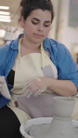 woman making pottery on a wheel