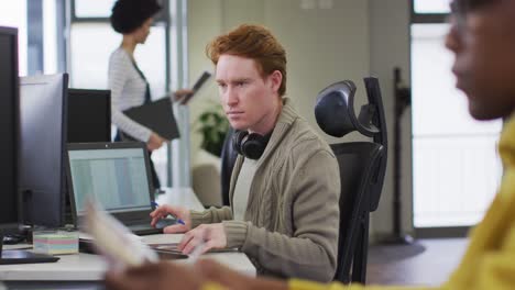 Porträt-Eines-Kaukasischen-Kreativen-Geschäftsmannes,-Der-Einen-Computer-In-Einem-Modernen-Büro-Verwendet