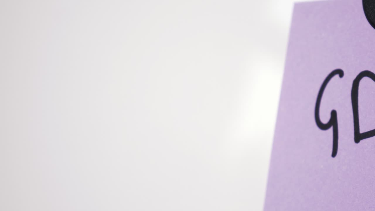 Pan reveal of GDPR text on purple note held by magnet on whiteboard with selective focus