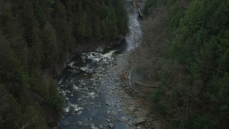 Shallow-River-Stream-Between-Forest-Mountain-In-Coaticook,-Quebec-Canada,-High-Angle-Shot