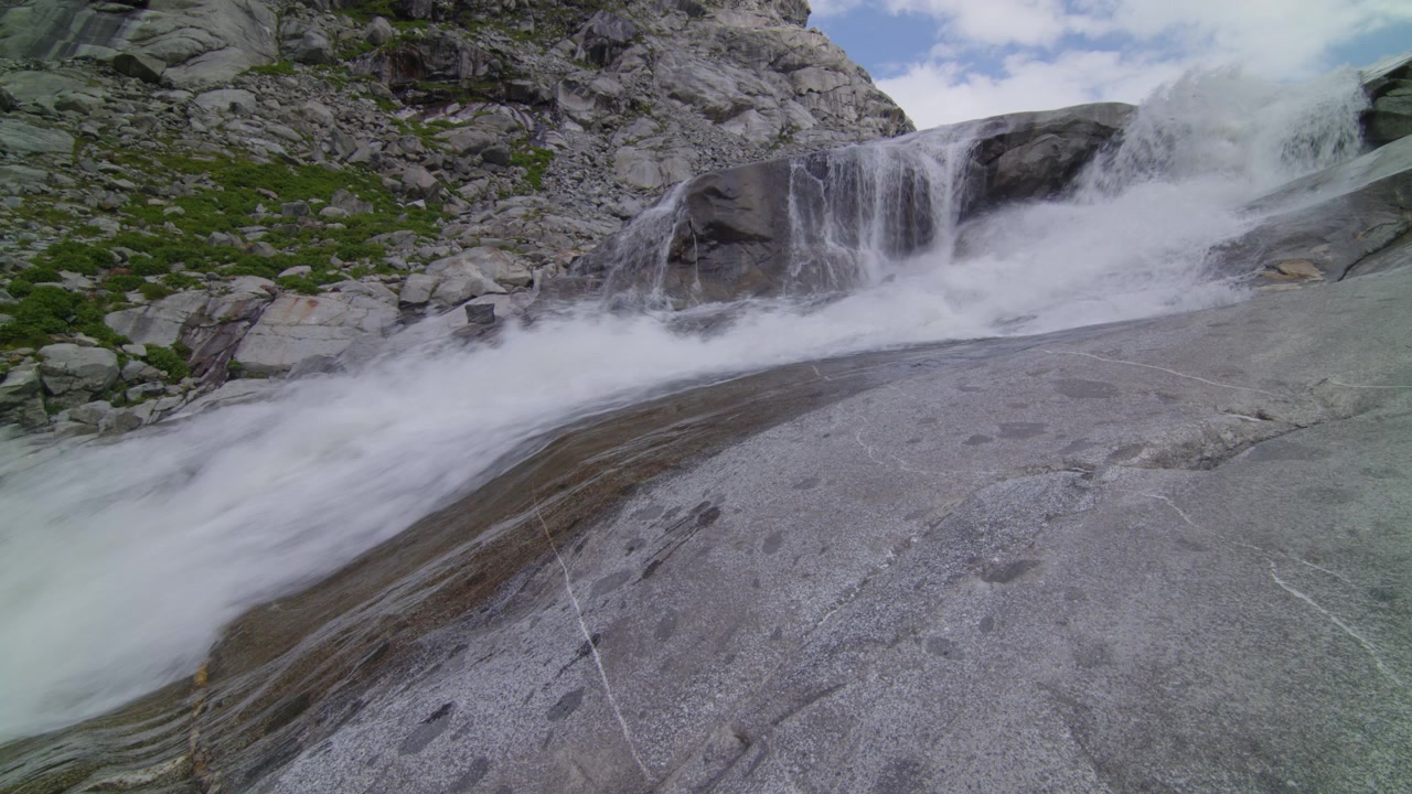 Ampia inquadratura di un fiume in alta montagna che scorre impetuoso in primavera. (Risoluzione 4K)