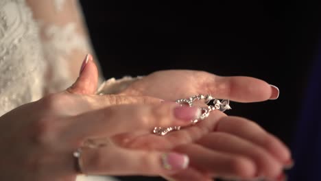 the bride holds beautiful earrings in her hands