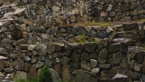 ornate stone cross in mtsvane monastery, ruined stone walls all around