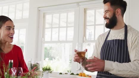 video de una feliz pareja caucásica cocinando y bebiendo vino