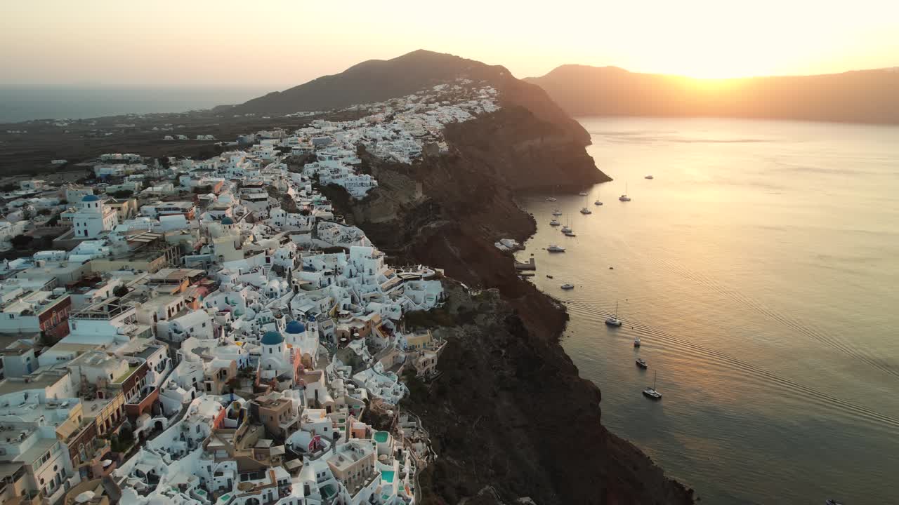 vista aérea de la puesta de sol sobre el mar egeo y la costa de la isla de santorini, grecia