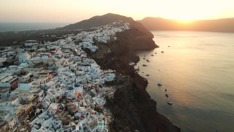 vista aérea de la puesta de sol sobre el mar egeo y la costa de la isla de santorini, grecia
