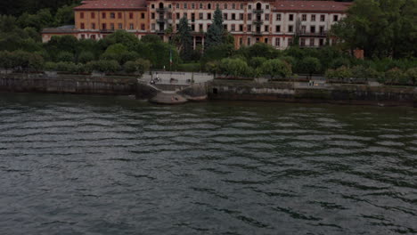 Drone-Volando-Sobre-La-Península-Llena-De-Hermosos-Edificios-En-La-Orilla-Del-Lago-De-Como,-Italia