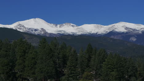 Cinematic-aerial-drone-reveal-zoom-in-first-snow-on-Mount-Blue-Sky-Evans-14er-peak-early-autumn-fall-beautiful-blue-bird-clear-morning-sunrise-day-Colorado-Rocky-Mountains-circle-left-movement