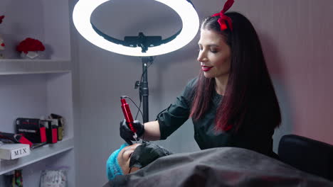 cosmetologist makes permanent makeup. cosmetologist doing permanent makeup in a beauty salon