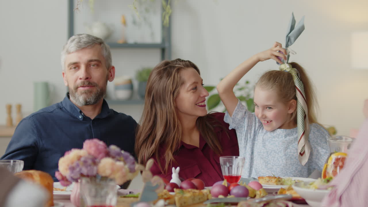 Little Girl Playing with Parents on Easter Dinner