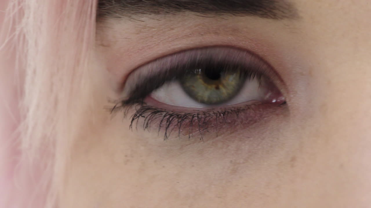 mujer de cerca ojo abierto mirando a la cámara punk mujer de cabello rosa