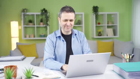 Home-office-worker.-He-also-uses-a-laptop-while-talking-on-the-phone.