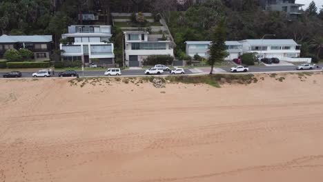 Dron-Dando-Marcha-Atrás-Hacia-El-Mar-Mostrando-Propiedades-Inmobiliarias-Caras-En-La-Costa