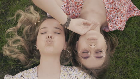 two friends lying on grass