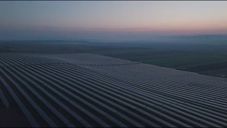 Ein-Riesiger-Solarpark-In-Der-Abenddämmerung-In-Einer-Ländlichen-Landschaft,-Luftaufnahme